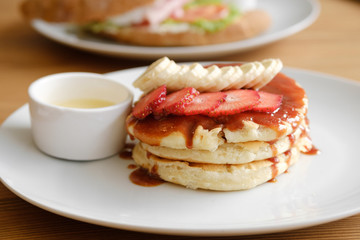 Delicious pancakes with strawberries, bananas and sauce. Cafe Breakfast Concept