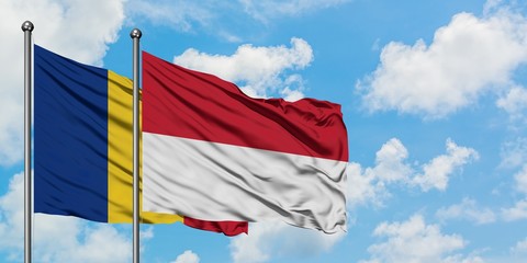 Romania and Indonesia flag waving in the wind against white cloudy blue sky together. Diplomacy concept, international relations.