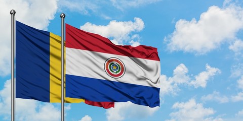 Romania and Paraguay flag waving in the wind against white cloudy blue sky together. Diplomacy concept, international relations.