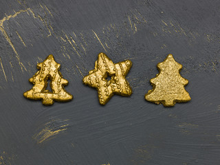 many different golden christmas cookies on black, golden background