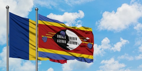 Romania and Swaziland flag waving in the wind against white cloudy blue sky together. Diplomacy...