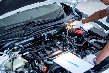 Fototapeta premium Auto mechanic (or technician) checking car engine at the garage
