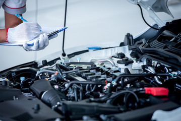 Fototapeta premium Auto mechanic (or technician) checking car engine at the garage