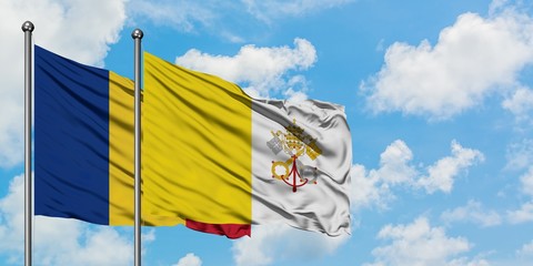 Romania and Vatican City flag waving in the wind against white cloudy blue sky together. Diplomacy concept, international relations.