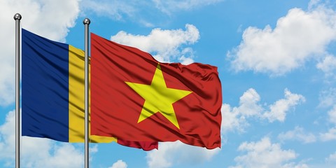 Romania and Vietnam flag waving in the wind against white cloudy blue sky together. Diplomacy concept, international relations.