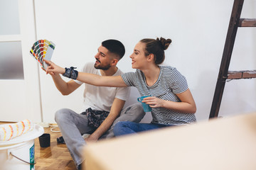 young couple choosing color for indoor walls in their new home
