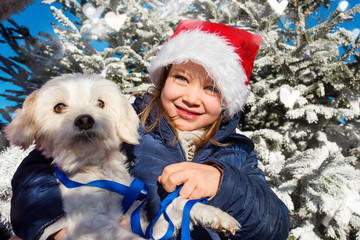 portrait of a beautiful girl with her dog at Christmas