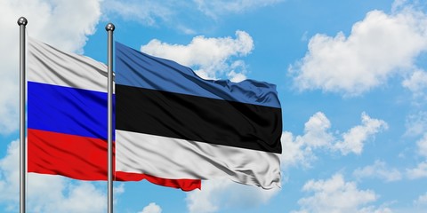 Russia and Estonia flag waving in the wind against white cloudy blue sky together. Diplomacy concept, international relations.