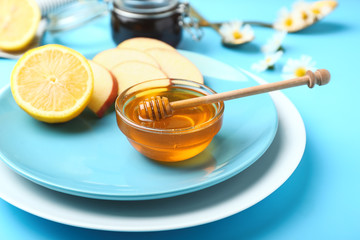 Plate with tasty honey and fresh fruits on table