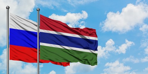 Russia and Gambia flag waving in the wind against white cloudy blue sky together. Diplomacy concept, international relations.