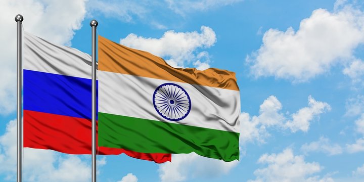 Russia and India flag waving in the wind against white cloudy blue sky together. Diplomacy concept, international relations.