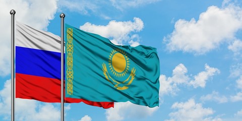 Russia and Kazakhstan flag waving in the wind against white cloudy blue sky together. Diplomacy concept, international relations.