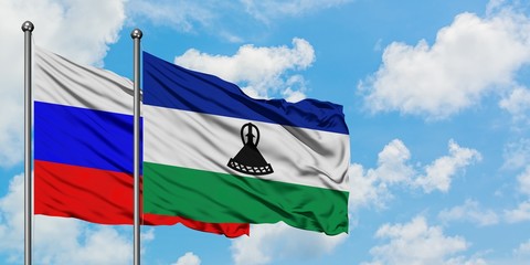 Russia and Lesotho flag waving in the wind against white cloudy blue sky together. Diplomacy concept, international relations.