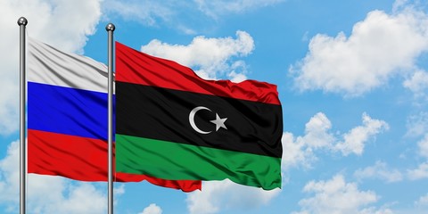 Russia and Libya flag waving in the wind against white cloudy blue sky together. Diplomacy concept, international relations.