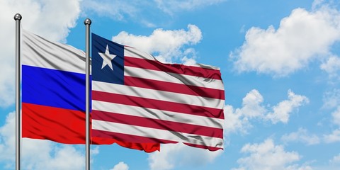 Russia and Liberia flag waving in the wind against white cloudy blue sky together. Diplomacy concept, international relations.