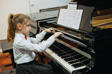 happy little girl teaching to play piano