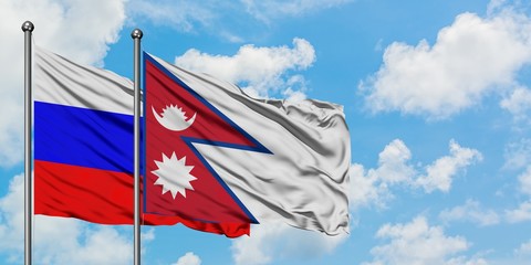 Russia and Nepal flag waving in the wind against white cloudy blue sky together. Diplomacy concept, international relations.