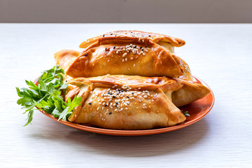 Samsa. Traditional oriental meat patties with parsley leaves on a plate