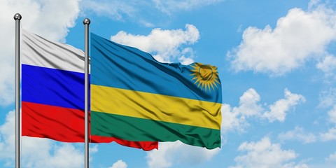 Russia and Rwanda flag waving in the wind against white cloudy blue sky together. Diplomacy concept, international relations.