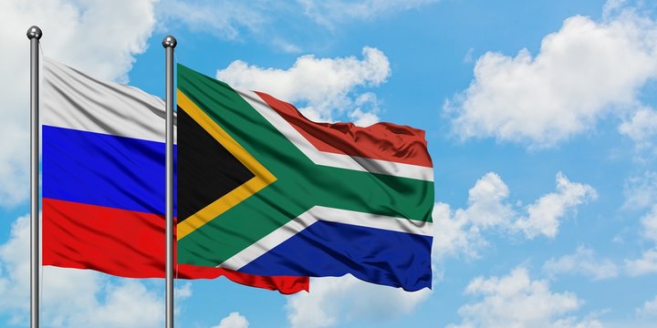 Russia and South Africa flag waving in the wind against white cloudy blue sky together. Diplomacy concept, international relations.