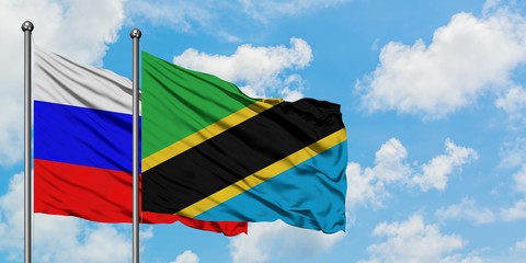 Russia and Tanzania flag waving in the wind against white cloudy blue sky together. Diplomacy concept, international relations.