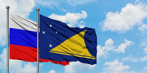 Russia and Tokelau flag waving in the wind against white cloudy blue sky together. Diplomacy concept, international relations.