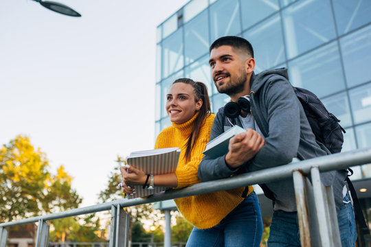 portrait of university students posing in front of glass building