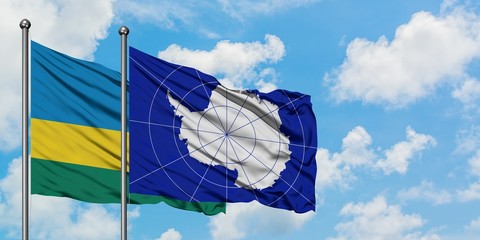 Rwanda and Antarctica flag waving in the wind against white cloudy blue sky together. Diplomacy concept, international relations.