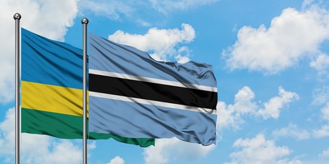 Rwanda and Botswana flag waving in the wind against white cloudy blue sky together. Diplomacy concept, international relations.