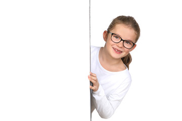 Kleines Mädchen mit Brille schaut lachend hinter einer Wand hervor