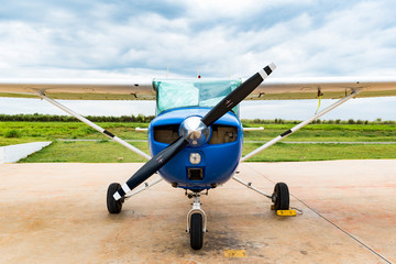 A blue single engine airplane or propeller aircraft on the ground
