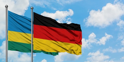 Rwanda and Germany flag waving in the wind against white cloudy blue sky together. Diplomacy concept, international relations.