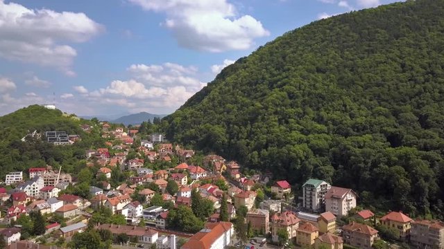 Aerial view of Brasov city, medieval town situated in Transylvania, Romania. Old architecture surrounded with big Carpathian mountains covered with dense green forest.