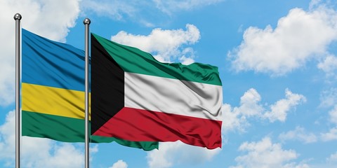 Rwanda and Kuwait flag waving in the wind against white cloudy blue sky together. Diplomacy concept, international relations.