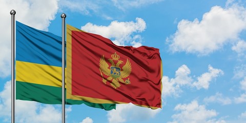 Rwanda and Montenegro flag waving in the wind against white cloudy blue sky together. Diplomacy concept, international relations.