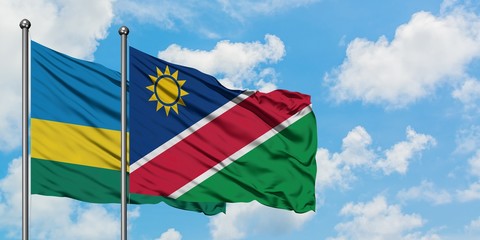 Rwanda and Namibia flag waving in the wind against white cloudy blue sky together. Diplomacy concept, international relations.