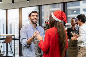 office christmas party. Merry Christmas and Happy New Year Multiracial young creative people are celebrating holiday in modern office. Group of young business people are drinking champagne