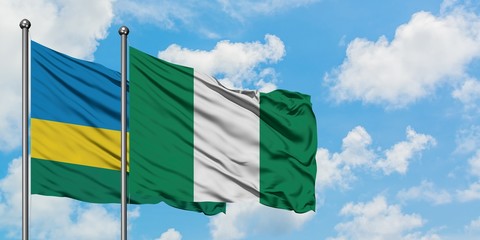 Rwanda and Nigeria flag waving in the wind against white cloudy blue sky together. Diplomacy concept, international relations.