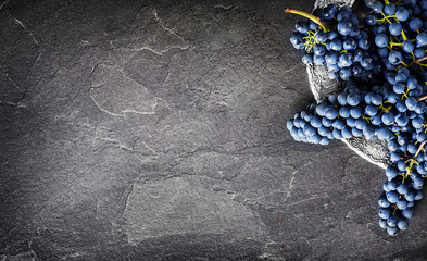 FInest home bunch of grapes on dark stone table on silver plate top view. Fresh grape on black...