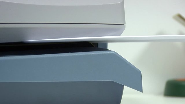 Franking machine producing a stack of freshly postaged invoice letter - very close detail shot.