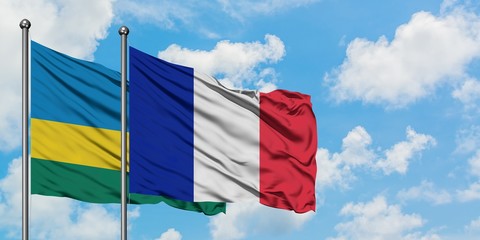 Rwanda and Reunion flag waving in the wind against white cloudy blue sky together. Diplomacy concept, international relations.