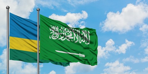 Rwanda and Saudi Arabia flag waving in the wind against white cloudy blue sky together. Diplomacy concept, international relations.