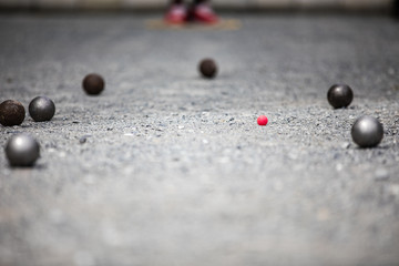 Petanque ball boules and small red jack on petanque field, Man playing petanque