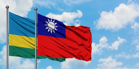 Rwanda and Taiwan flag waving in the wind against white cloudy blue sky together. Diplomacy concept, international relations.