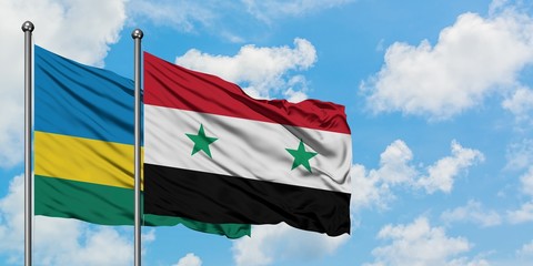 Rwanda and Syria flag waving in the wind against white cloudy blue sky together. Diplomacy concept, international relations.