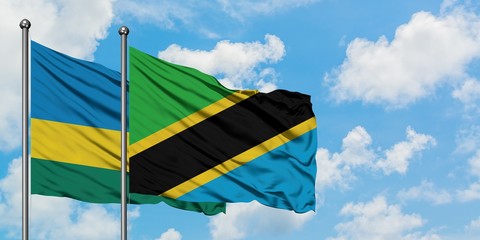 Rwanda and Tanzania flag waving in the wind against white cloudy blue sky together. Diplomacy concept, international relations.