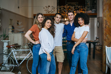 Portrait of a group of friends standing at home and look in the camera - Millennials are having fun together in an apartment