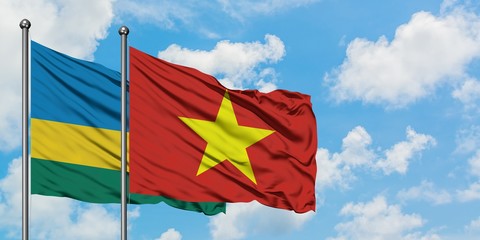 Rwanda and Vietnam flag waving in the wind against white cloudy blue sky together. Diplomacy concept, international relations.