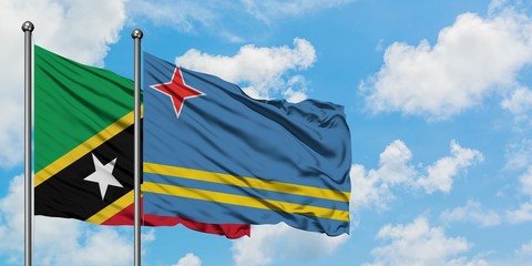 Saint Kitts And Nevis and Aruba flag waving in the wind against white cloudy blue sky together. Diplomacy concept, international relations.