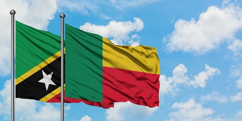 Saint Kitts And Nevis and Benin flag waving in the wind against white cloudy blue sky together. Diplomacy concept, international relations.